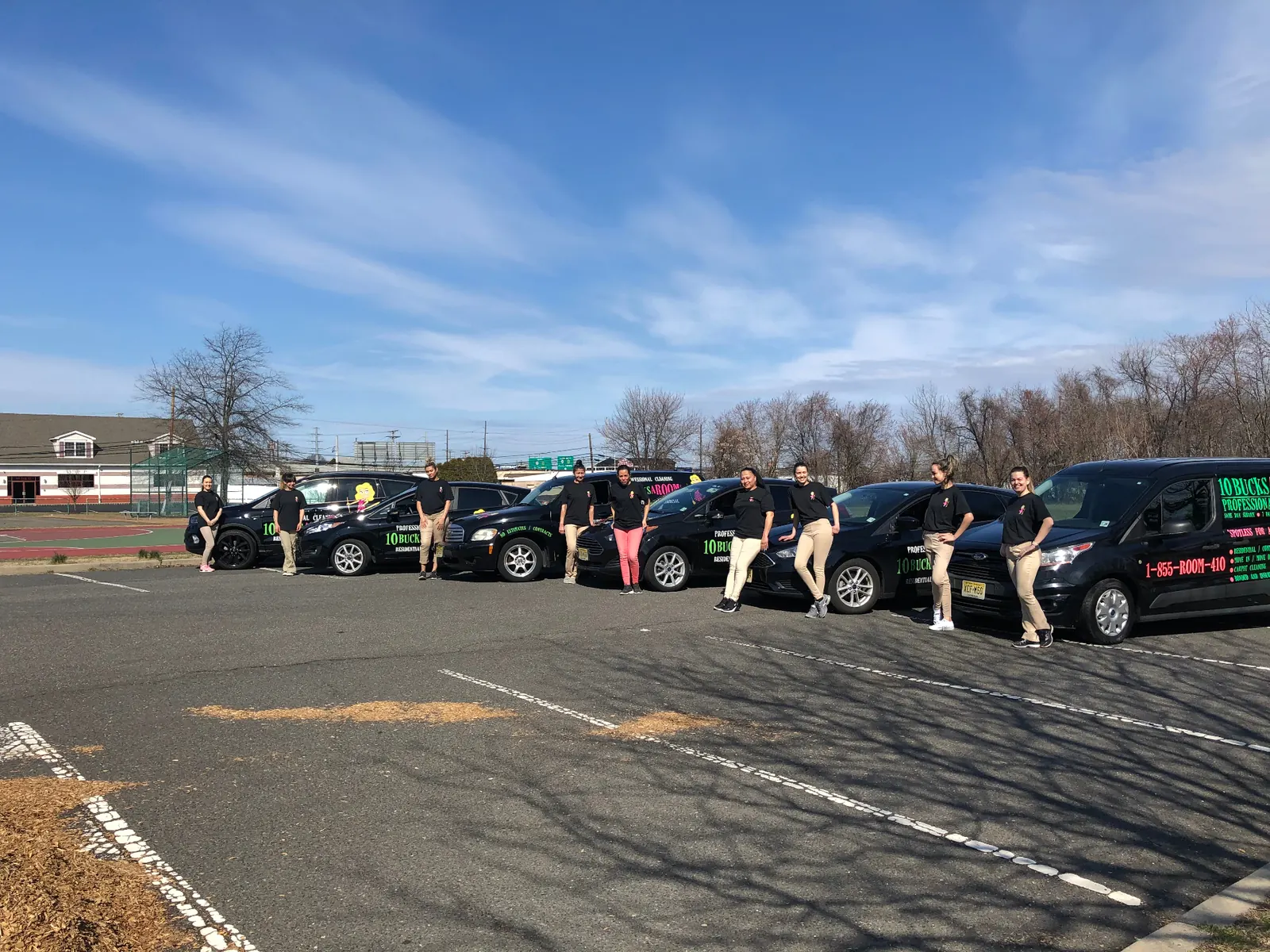 A fleet of branded 10BucksARoom vans lined up with their teams — operator scaled to multiple vehicles