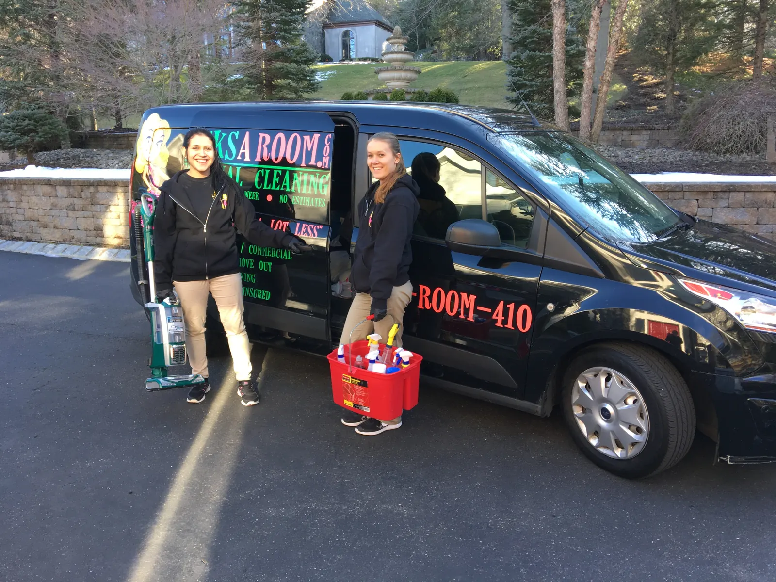 Two 10BucksARoom team members beside a single branded service van — day one of an operator's territory